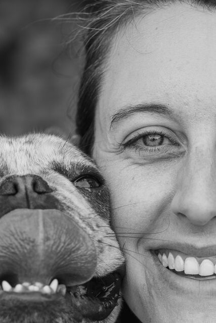 Black-and-white close-up of a woman beside a small dog